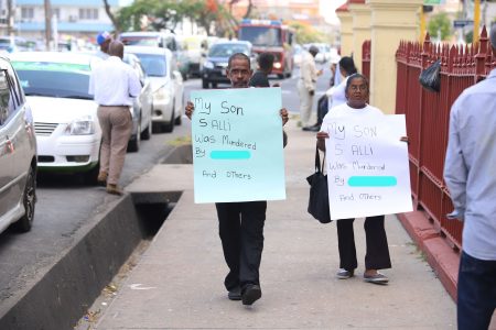 The parents of Shaheed Ally, the remanded prisoner who was fatally beaten by fellow inmates while in custody at the Lusignan Prison, protested outside of the Georgetown Magistrates’ Courts yesterday to seek justice for him. The protest coincided with the second appearance of Ally’s co-defendant, Malcolm Collie, with whom he had been charged over the murder of Sumintra Dinool, an elderly Albouystown businesswoman who was found dead in her home in 2014. Ally, 30, was attacked hours after being booked into the Lusignan Prison and days later succumbed to the injuries. The police are yet to identify the prisoner/s responsible. (Photo by Terrence Thompson)  