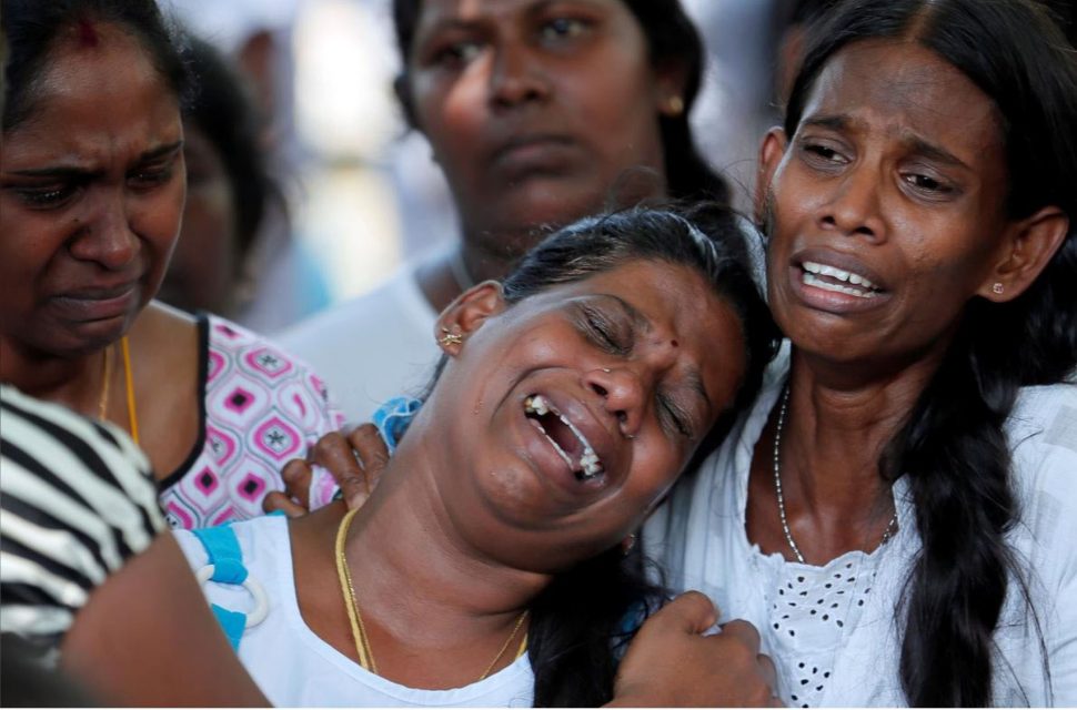 People react yesterday during mass burials of victims of a string of suicide bomb attacks in Sri Lanka on Easter Sunday. REUTERS/Dinuka Liyanawatte
