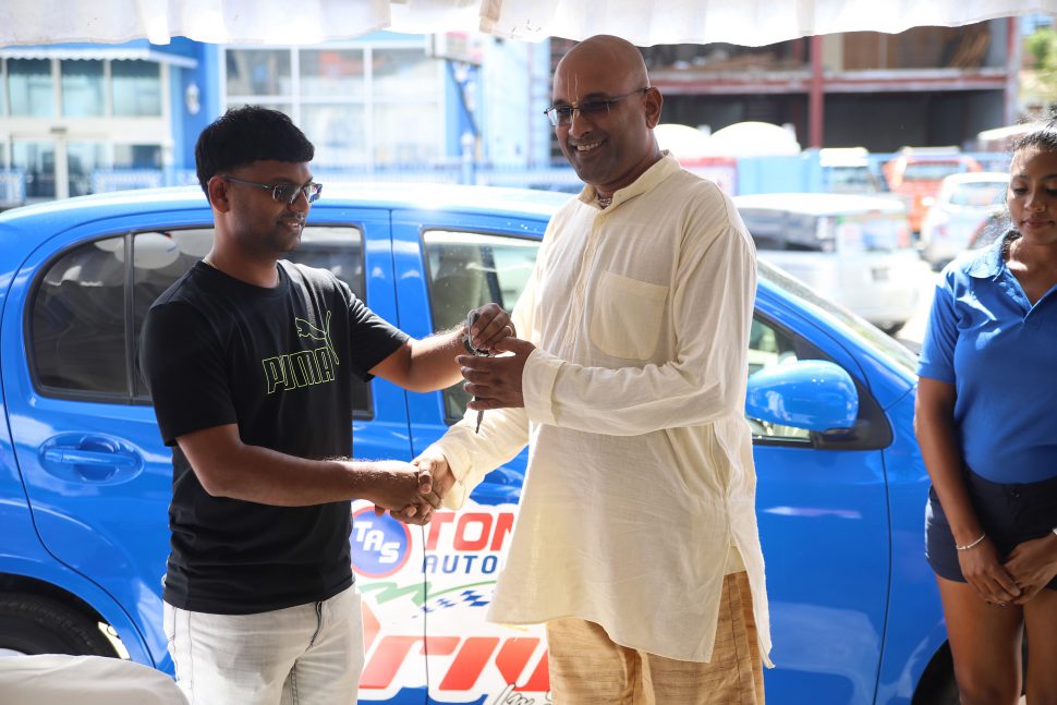 A representative of Tony’s Auto Spares handing over the keys of the Toyota Passo to Chaitram Dhanesar, at an official handing over ceremony held at the company’s Light Street branch in Georgetown, yesterday. (Terrence Thompson photo)