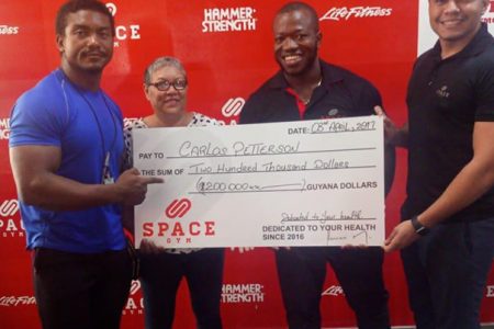 Carlos ‘The Showstopper’ Petterson-Griffith hard work is reaping rewards. He was presented with a cheque for $200,000 from Space Gym’s Lucas Matos (extreme right) yesterday to aid with his expenses for the World Classic Powerlifting Championships in Sweden.