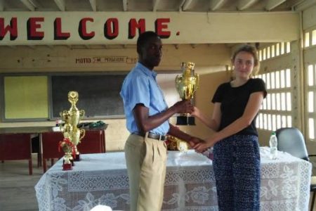 Murphy Bagot (left) a student of the New Amsterdam Multilateral Secondary School, placed first in the individual category of the 2019 Berbice Inter-School Chess Championship held at the St Aloysius Primary School. He receives his chess trophy from Georgia Howton, English teacher of the Orealla Primary Top School. The word ‘Top’ is used to describe the school because it carries a secondary science department. (Photo: Krishnanand Raghunandan) 