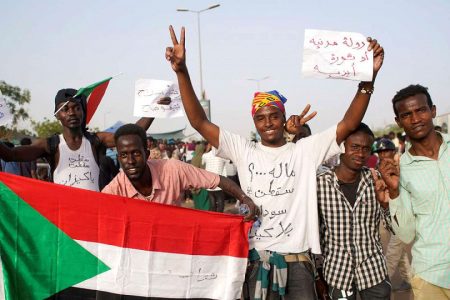 Sudanese demonstrators hold a national flag and chant slogans as they protest against the armys announcement that President Omar al-Bashir would be replaced by a military-led transitional council, outside Defence Ministry in Khartoum, Sudan April 11, 2019. REUTERS/Stringer 