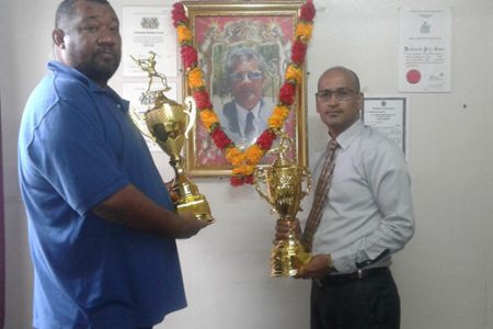 BCB President Hilbert Foster and sponsor Attorney-at-Law Arudranauth Gossai pose with the trophies.
