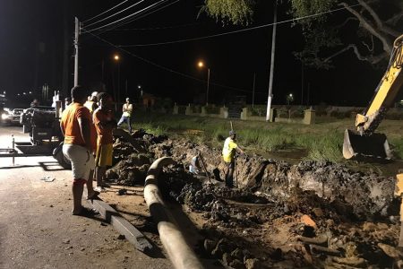 Guyana Water Inc personnel working last night on the ruptured transmission line on Church Street.  (GWI photo)

