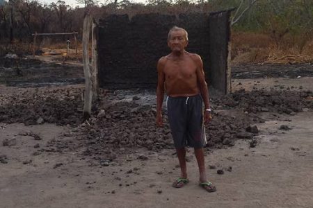 Farmer Mario Edwards standing in front of the destroyed structure he once called home.