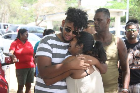 Siblings Kevon and Kimberly Gyandass comfort each other after their father Seunarine Gyandass’ life jacket was found yesterday at sea, after his boat sunk off the Gulf of Paria on Sunday.    