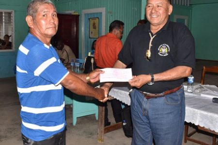 Parakese Senior Councillor, Terrence Edwards (left) receiving a cheque from Minister of Indigenous Peoples’ Affairs, Sydney Allicock. (DPI photo)