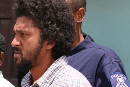Brian Mc Kenzie escorted to the Sangre Grande Magistrates Court on Wednesday.