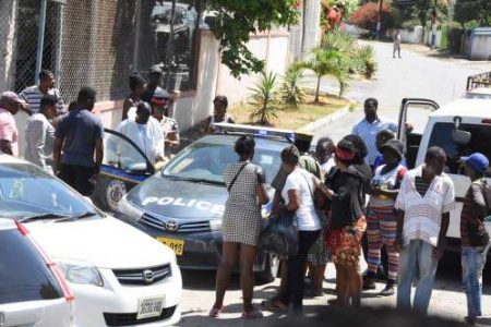 Onlookers at the scene of the murder-suicide on Waltham Park Road in Kingston, yesterday. 