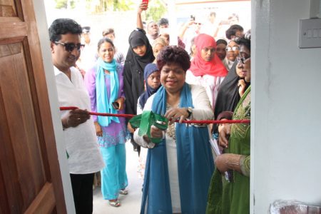 Minister of Social Protection Amna Ally (centre) is assisted by former Attorney General Anil Nandlall (left) in cutting the ceremonial ribbon declaring the home open.