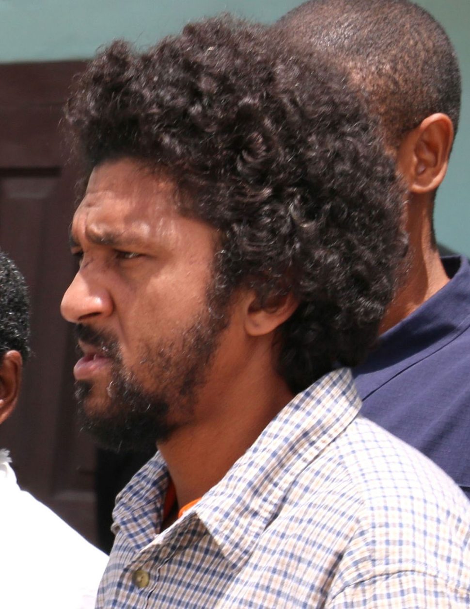 Brian Mc Kenzie being escorted to the Sangre Grande Magistrates Court on Wednesday.