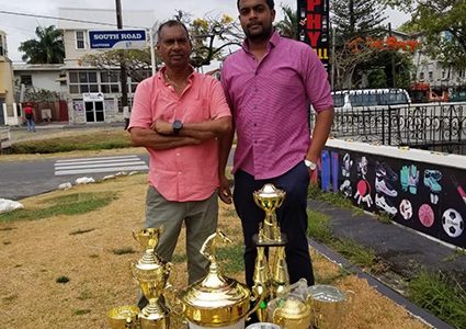 Managing Director of the Trophy Stall, Ramesh Sunich and boss of the JJTRC, Nasrudeen Mohamed Jr. pose with the trophies that will be up for grabs today at the Port Mourant Turf Club.