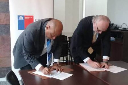 Minister of Natural Resources Raphael Trotman (left) and Chile’s Minister of Mining Baldo Prokurica signing the MOU