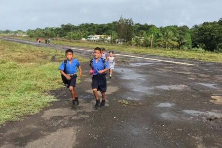 Schoolchildren using the airstrip to attend school