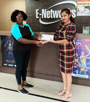 Guyana Committee of Service’s Avril Black (left) receives the sponsorship from E-Networks Vanita Persaud.