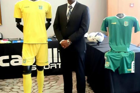 President of the Guyana Football Federation, Wayne Forde poses next to the perspective Guyana Jaguars kit by Capelli Sport.