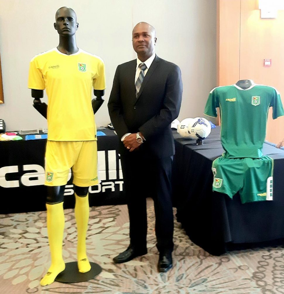 President of the Guyana Football Federation, Wayne Forde poses next to the perspective Guyana Jaguars kit by Capelli Sport.