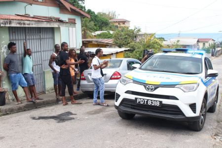 People in th Carenage area react to the presence of police officers at Big Yard yesterday, after the shootout between residents and Western Division officers on Friday night.