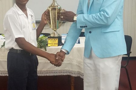 Winner of the Mathematics Quiz, Dave Chowtie receiving his trophy from District Education Officer,  Adrian Elgin (Ministry of Education photo)
