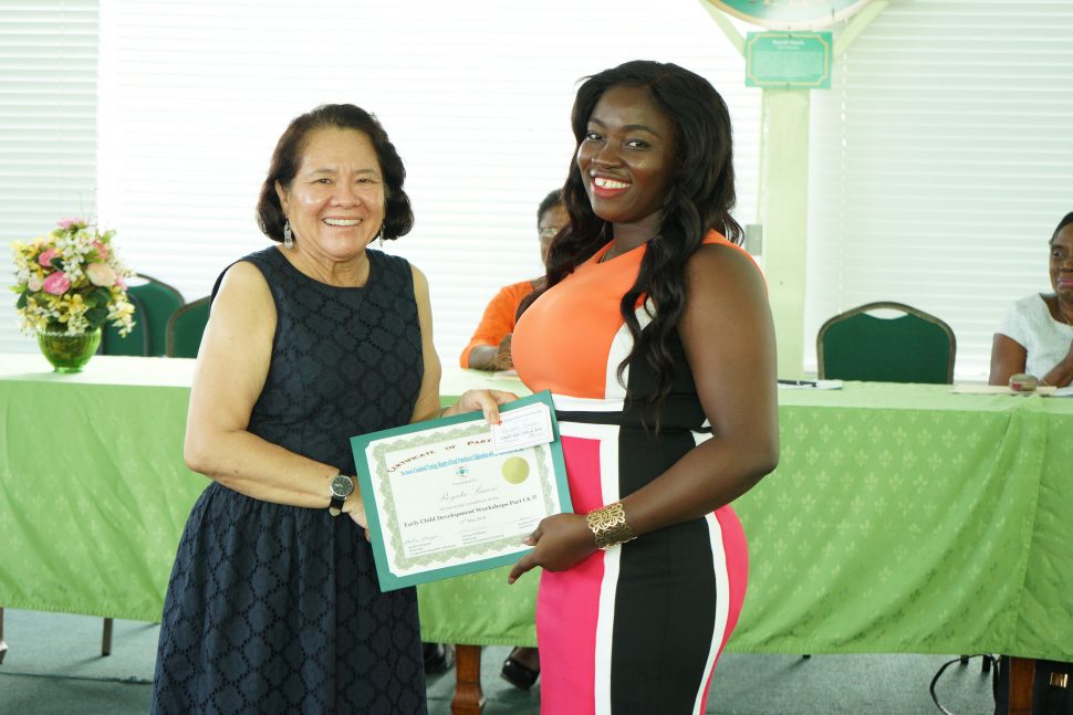 First Lady, Sandra Granger (left) presents graduate Reyata Simon with her certificate of completion at the at the graduation ceremony. (Ministry of the Presidency photo)