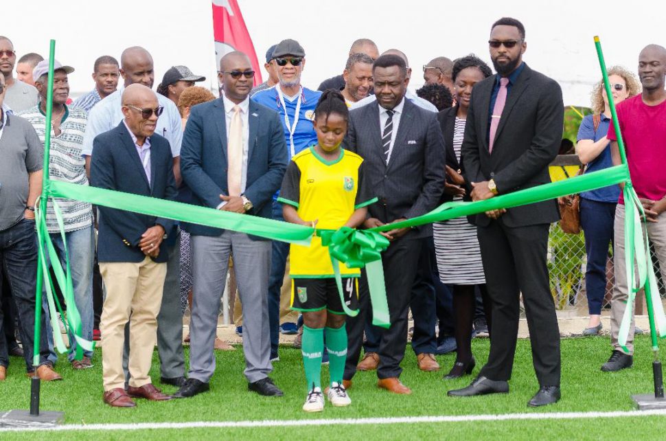 Lady Jaguars Junior National Player Aliyah Elaine [center] cuts the ribbon to officially commission the GFF’s first  FIFA Forward Project following yesterday’s inauguration ceremony in the presence the GFF Executive Committee, Director of Sports Christopher Jones, FIFA Director of Member Associations and Development Veron Mosgengo-Omba and participants and delegates of the FIFA Conference on Development.