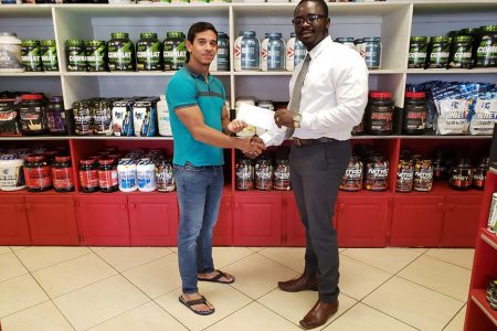 President of the GBBFFI, Keavon Bess (right) receiving the sponsorship cheque from Fitness Express’ CEO, Jamie McDonald yesterday at the company’s store at 47 John and Sheriff Streets.
