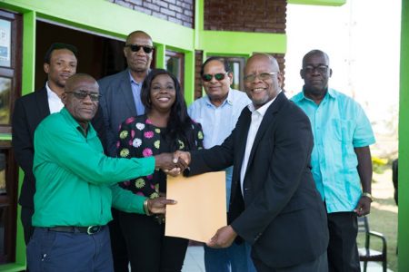 NCN’s Chairman, Enrico Woolford (second from right) hands over documents to Chairman of LBN, Renis Morian. (DPI photo)