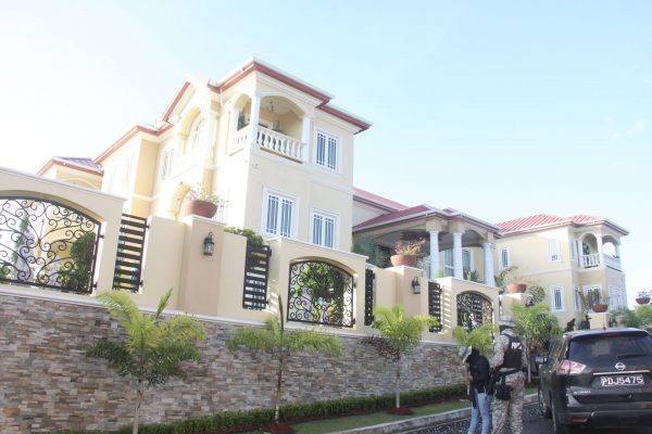 SORT officers stand guard outside the Gulf View, La Romaine home of businessman Simon Alexander yesterday. The officers raided the mansion and six other properties during an exercise.