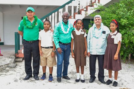 From left to right, Minister of Social Cohesion, Dr. George Norton; Minister within the Ministry of Social Protection, with responsibility for Labour , Keith Scott and Minister within the Ministry of Finance, Jaipaul Sharma with schoolchildren (DPI photo)