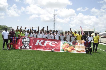 The newly crowned KFC Independence U20 Club Knockout Football Championship East Bank Demerara champion Timehri Panthers are celebratory mood following their win over Soesdyke Falcons. Also in the photo are GFF President Wayne Force [2nd from left] and EBFA President Franklin Wilson [left]