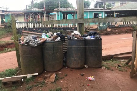 Barrels of garbage overflowing in the Port Kaituma Police Station compound 