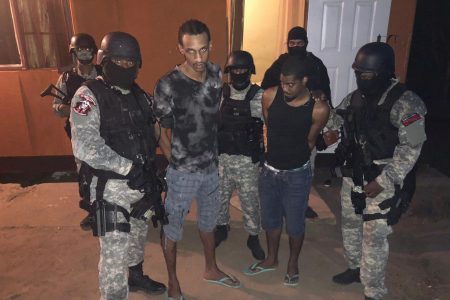 Escapees Olatunge Denbow and Michael Findley surrounded by officers from the Special Operations Response Team (SORT) moments after they were caught in a house at Lp 52 Ralph Narine Trace, South Oropouche.