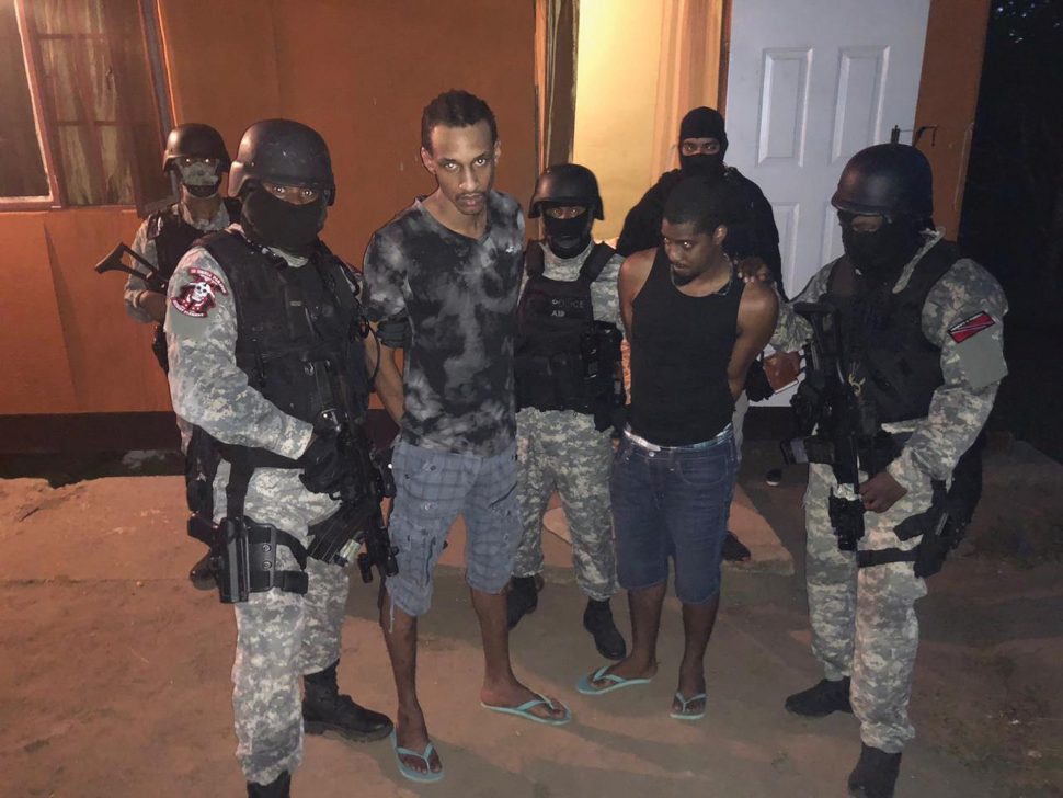 Escapees Olatunge Denbow and Michael Findley surrounded by officers from the Special Operations Response Team (SORT) moments after they were caught in a house at Lp 52 Ralph Narine Trace, South Oropouche.