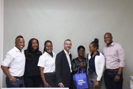 Ackaisha Green (third right) is flanked by Nestle Jamaica executives (from left) Garfene Grandison, general manager Nestle Jamaica Health and Wellness Foundation (NJHWF); Rhona Morgan, legal manager and compliance officer; Kadia Burrell, NJHWF events and programmes manager; Daniel Caron, country manager; Shawna Kidd, group marketing manager; and David Heath, human resource business partner. Green was presented with a one-year supply of groceries as well as supermarket vouchers to shop monthly at Nestle's Staff Shop. 