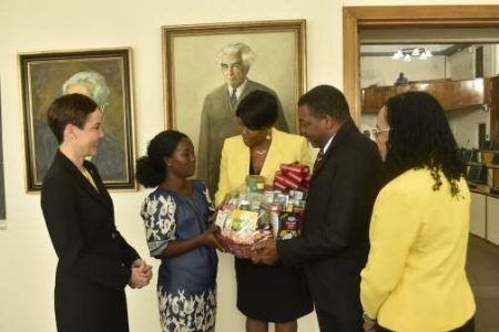 Ackaisha Green (second left) is presented with a gift basket by Acting Clerk to the Houses of Parliament, Valrie Curtis (centre); and Orderly, Chaddi Donaldson (second right), shortly before the sitting of the Senate on Friday (May 17). Green was being recognised for her honesty in returning a large sum of cash she found in an automated teller machine (ATM) in downtown Kingston recently. Looking on are Leader of Government Business, Senator Kamina Johnson Smith; and Leader of Opposition Business, Senator Donna Scott-Mottley. 