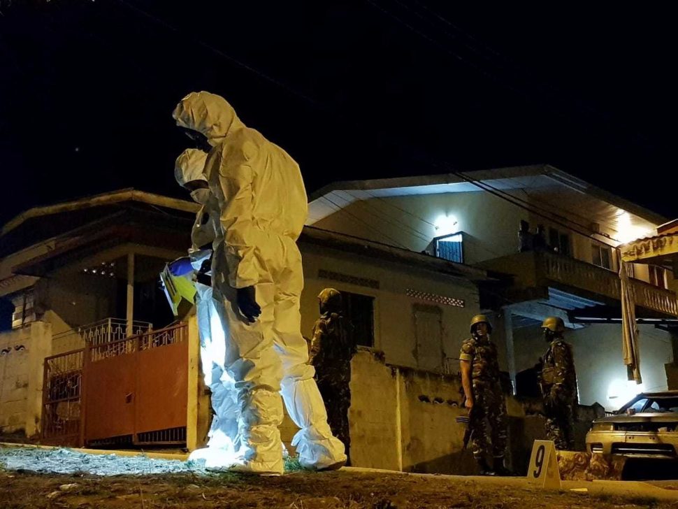 Soldiers keep watch as Crime Scene Investigators search for clues at Big Yard, Carenage, last night after a shooting incident
