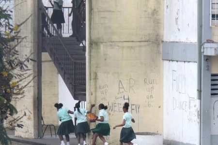Students of Siparia West Secondary School run towards the stairway on Monday as a fight broke out in one of the classrooms above.