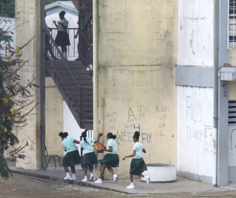 Students of Siparia West Secondary School run towards the stairway on Monday as a fight broke out in one of the classrooms above.