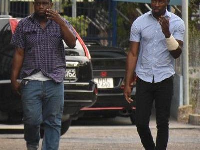 Police officer Akeel Boyce, left, and soldier Akim Brewster leave the San Fernando Magistrates’ Court yesterday after they were granted bail for allegedly maliciously wounding DJ Kevin Nedd last weekend.