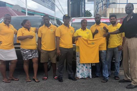 Minibus operatives attired in their gold t-shirts, pose for a photo with United Minibus Union President, Eon Andrews (right) in Bartica.
