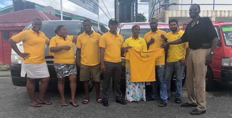 Minibus operatives attired in their gold t-shirts, pose for a photo with United Minibus Union President, Eon Andrews (right) in Bartica. 
