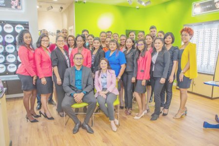 Narine and his wife Madonna (seated) pose with the staff of the various locations at Thursday’s opening of their fifth branch.
