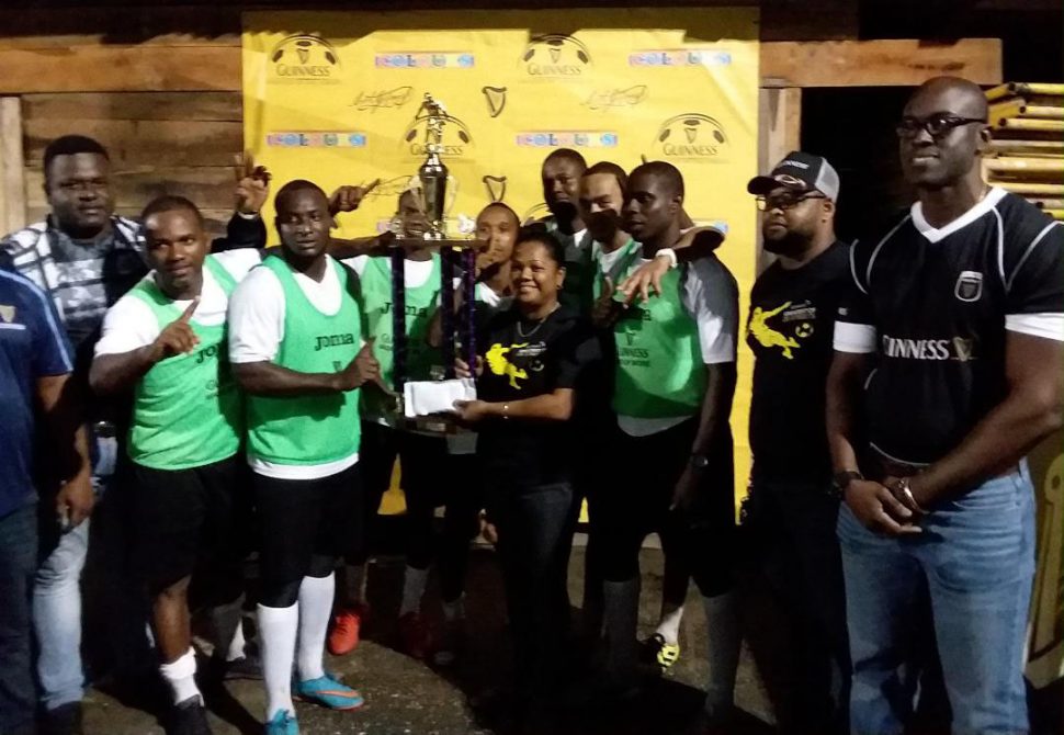 THE GREATEST!Beacons Captain Whitney Welcome receives the championship trophy from Banks DIH Bartica Branch Manager, Amanda Murray while his team mates share  the moment. Also present are Guinness Brand Executive Lee Baptiste and Bartica District Sales Supervisor Keron Savory
