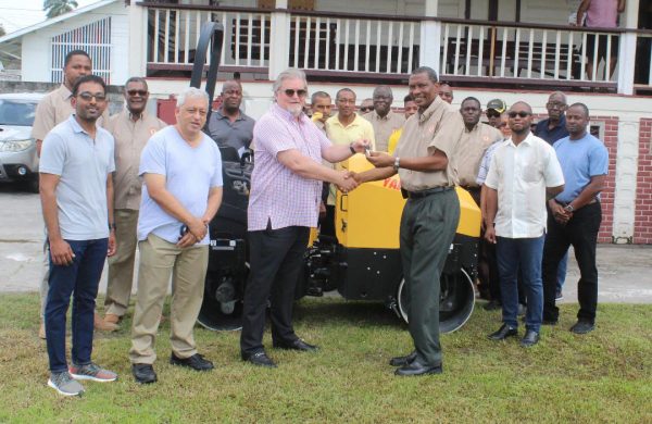 General Manager of Shore Bases Inc. Mark Edwards hands over the roller to the President of DCC Roger Harper, Saturday.
