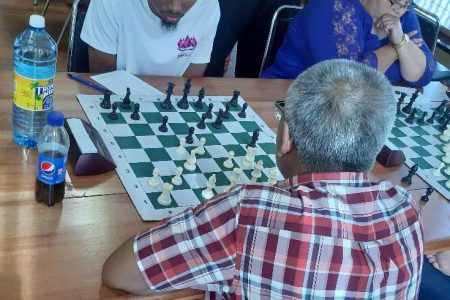 In this Romario Samaroo photo FIDE Master Anthony Drayton (in the white shirt) is calculating his next move in the final round match against Shivanand Nandalall.
