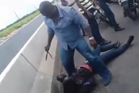 A policeman stands over the female motorcyclist after she was reportedly slammed to the ground in this screenshot from the video recording of the incident.