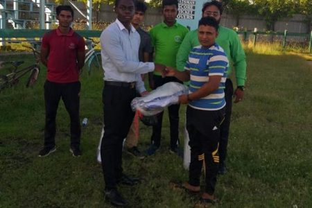 BCB PRO Simon Naidu (right) hands over cricket gears to a member of the UGBC elites in the presence of members of the Rose Hall Town Youth and Sports Club