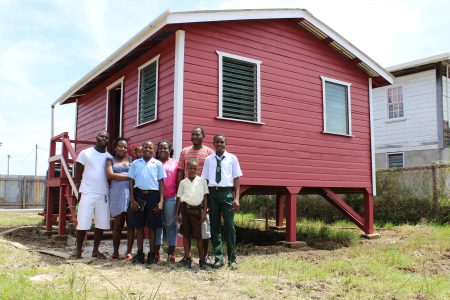 A family poses with one of the houses built