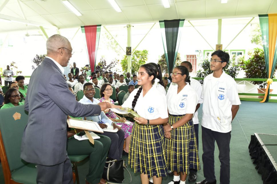 President David Granger receives a framed copy of a poem written by students of the Marian Academy yesterday morning at the observance of World Environment Day 2019.  The poem was presented to the Head of State after it was performed by students of the school’s environmental club. (Ministry of the Presidency photo)