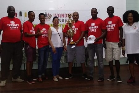 The victorious Gold Is Money team, from left, Clarence Whitehead, John `Paddy’ Chance, Anthony Solomon,  DDL’s Maria Munroe, Tony Ally, Shawn Morgan and Leroy `Pee Wee’ Edwards. At right is president of the Guyana National Dominoes Federation Faye Joseph.
